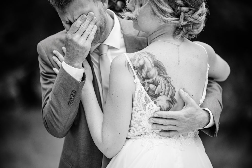 Bride comforts the groom as he gets emotional on their wedding day.