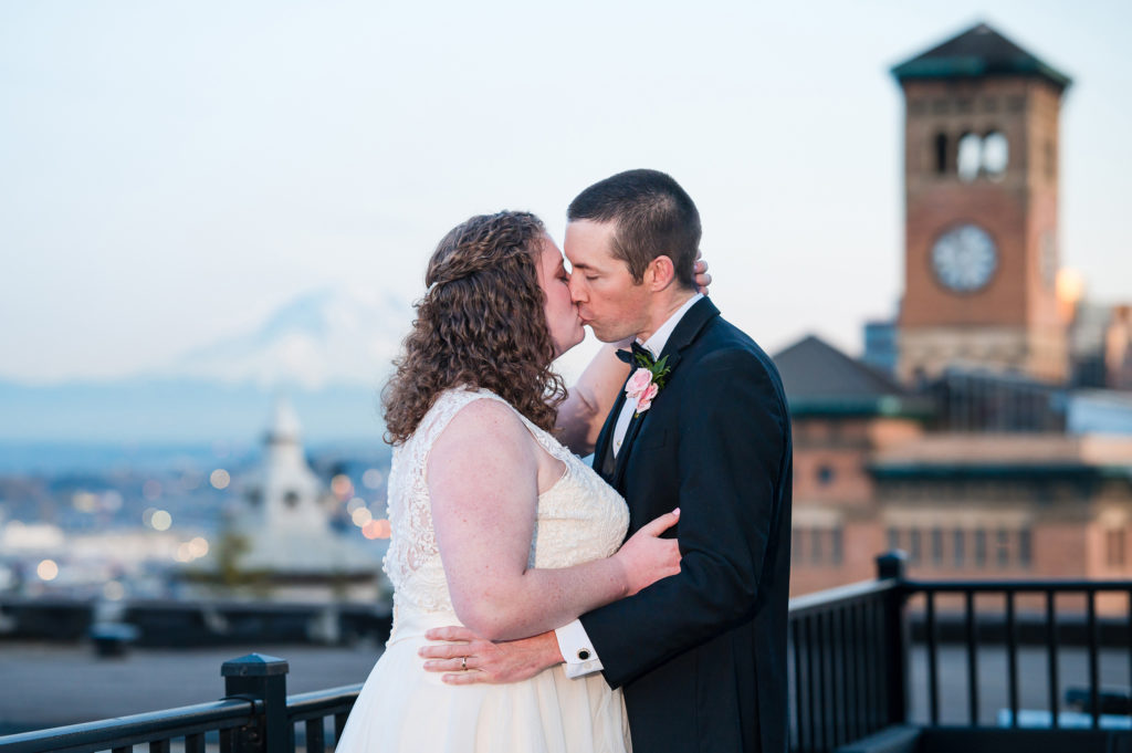 Bride and groom kissing at sunset at Union Club Tacoma wedding